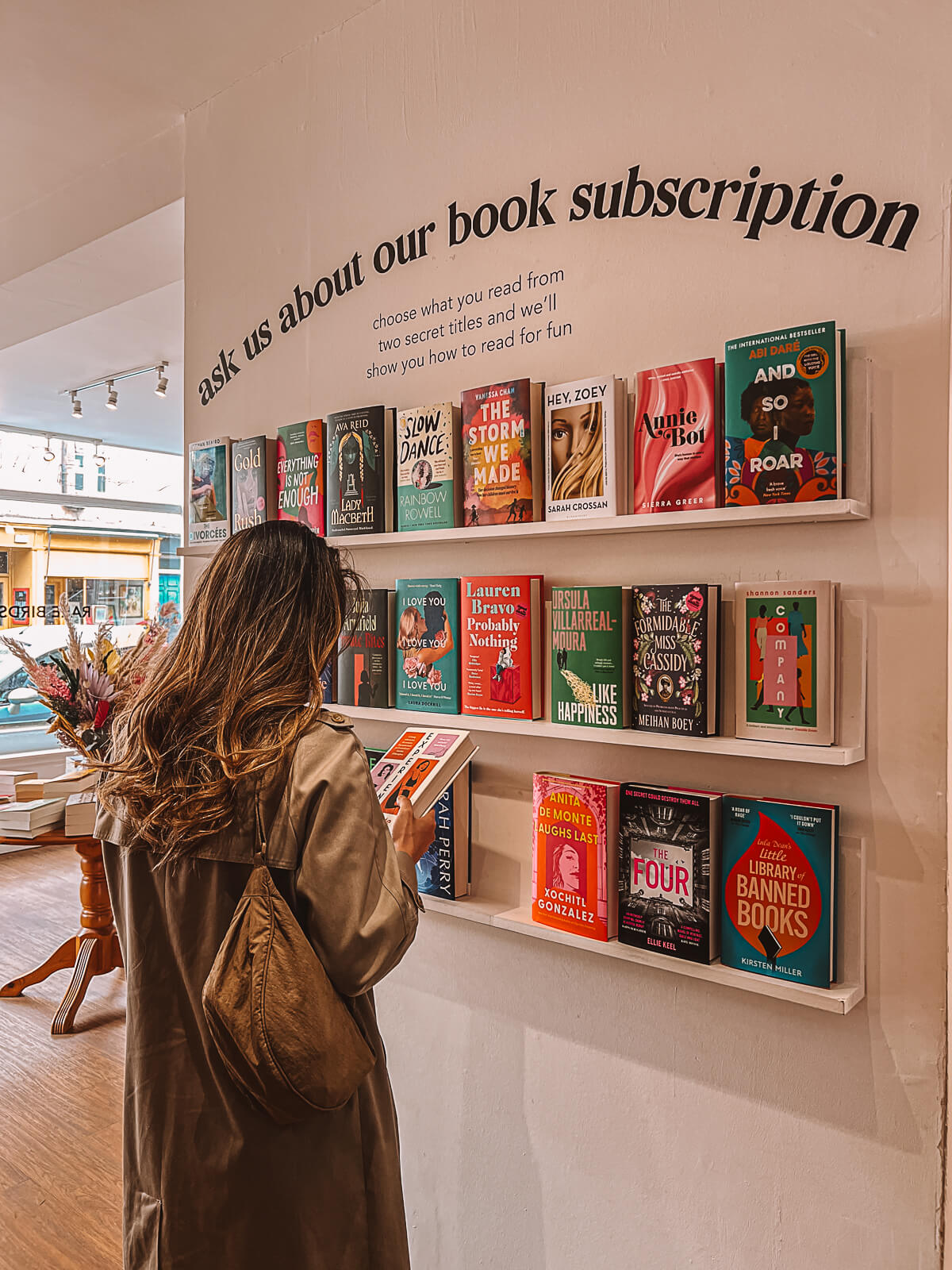 Woman browsing for books to read in a local bookshop in Edinburgh