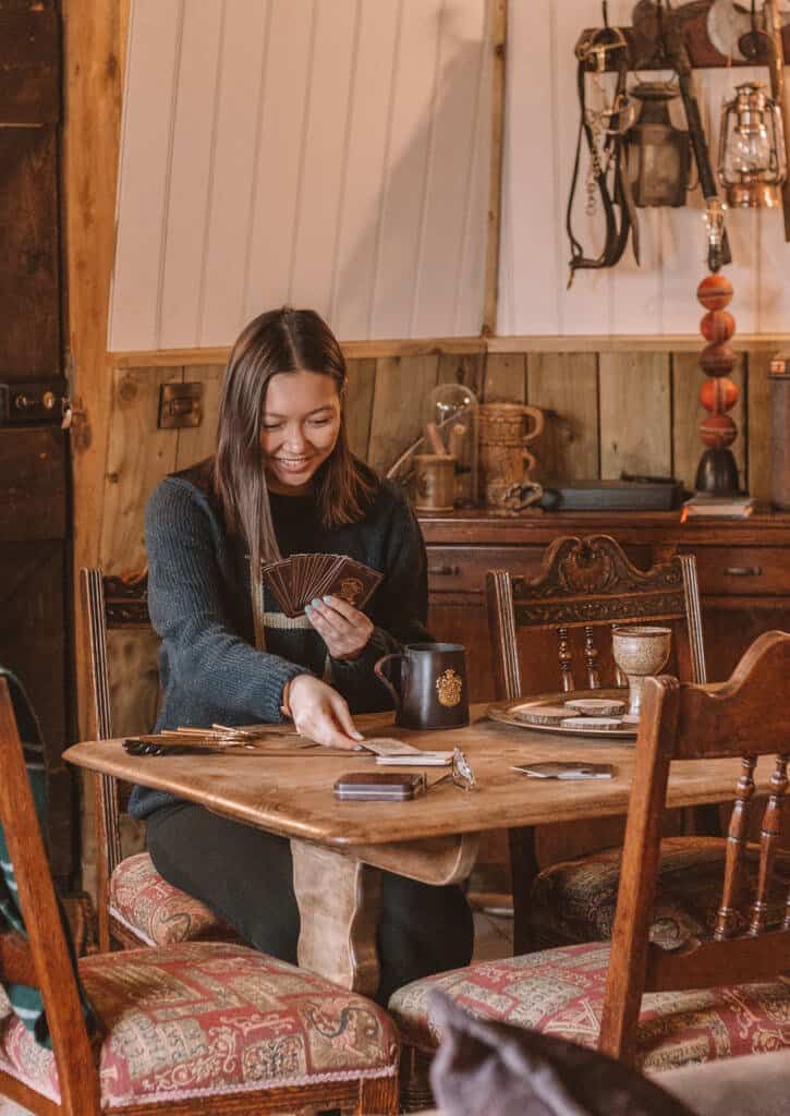 Girl playing cards in Ground Keeper's Cottage in North Shire