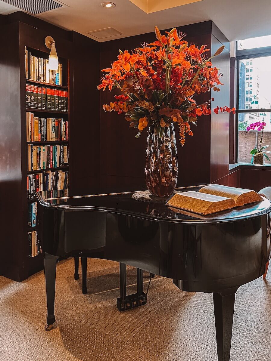 Guests library with a grand piano at Library Hotel New York city