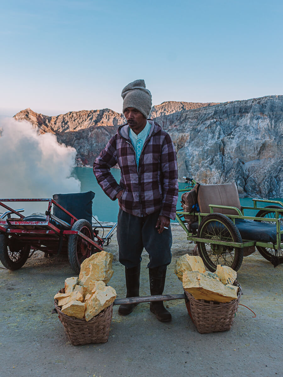 Miner on Mount Ijen with yellow sulphur blocks