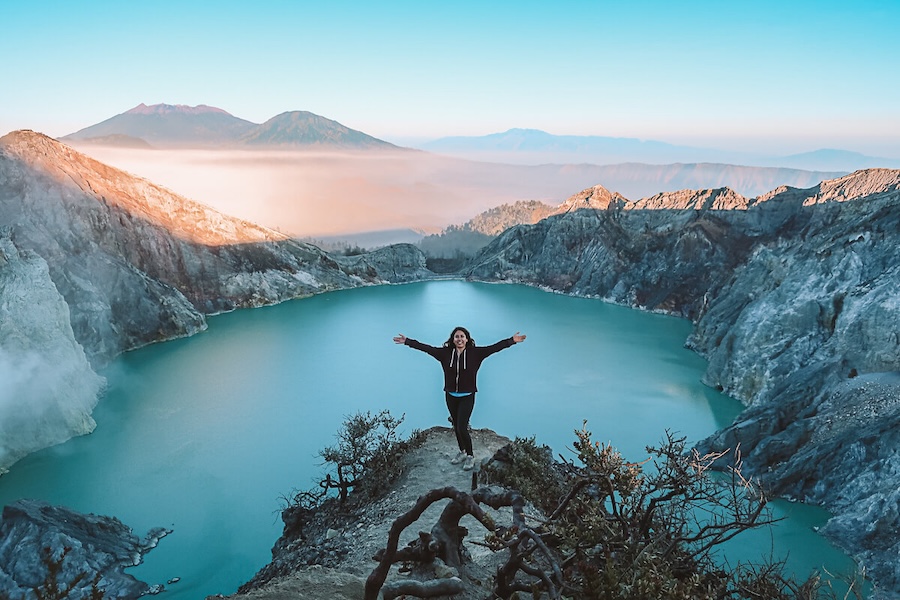 Woman stands atop the acid lake at Mount Ijen crater.