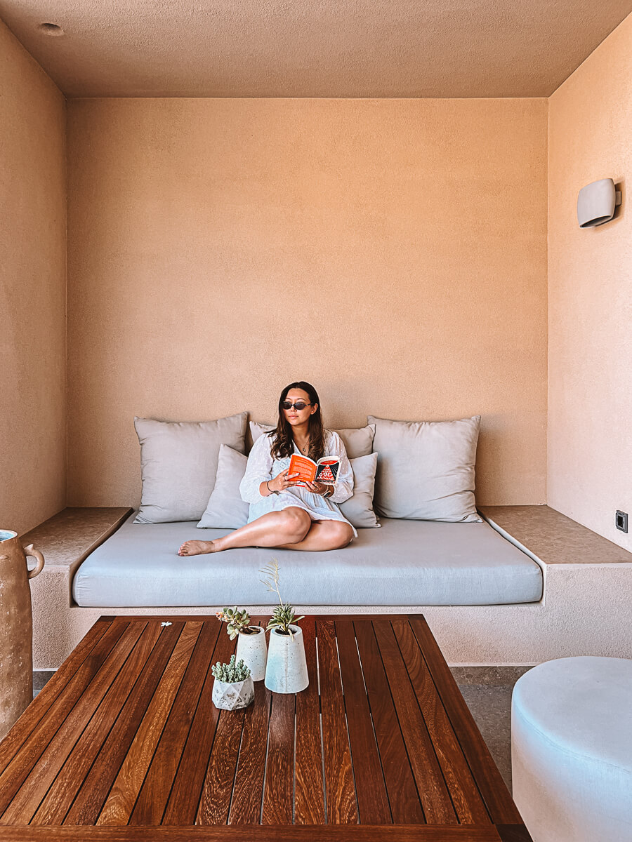 Woman on sofa reading book on reading retreat in Greece by Aweventurer 