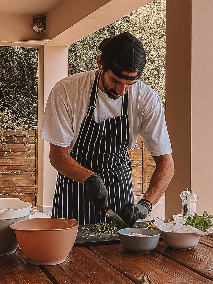 Greek chef in striped apron doing a Greek cooking demonstration on reading retreat in Zakynthos