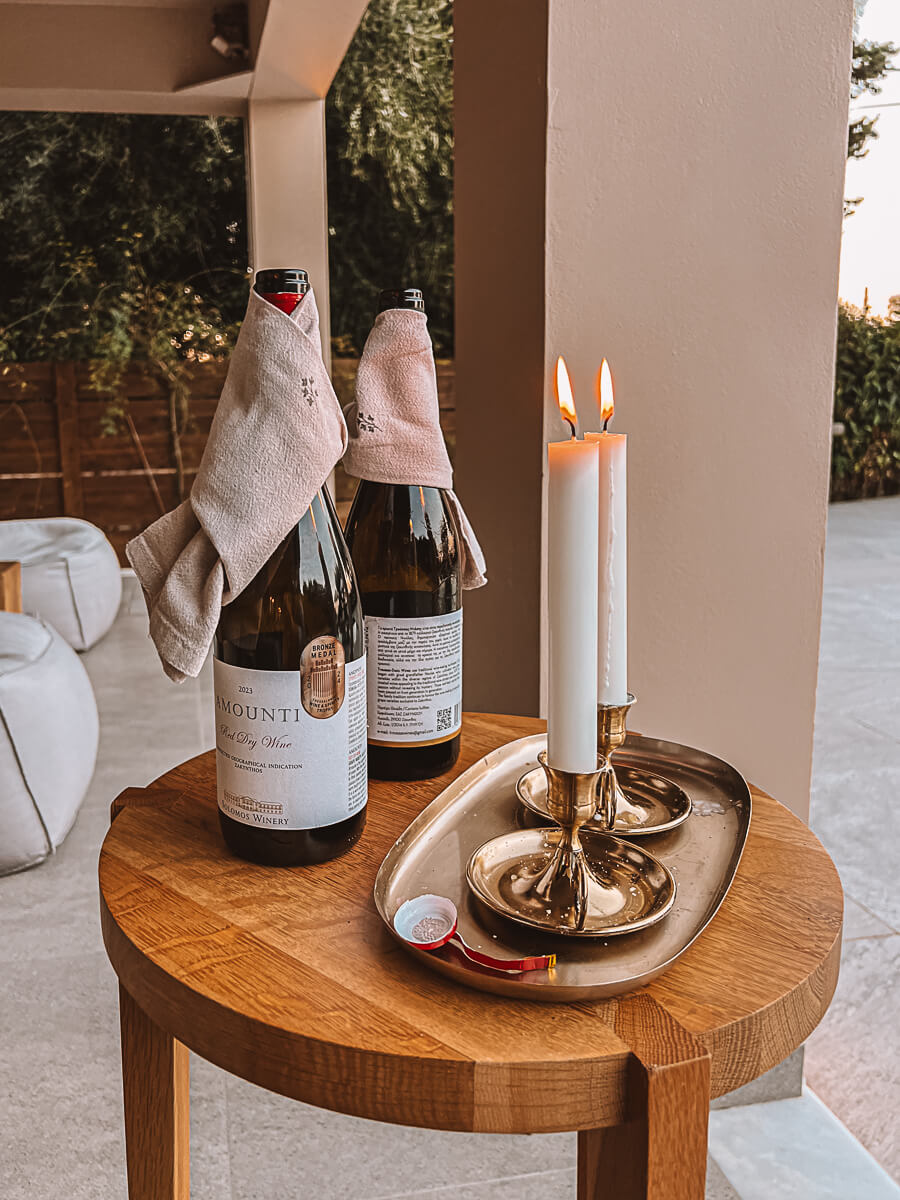Bottles of wine and long candles burning before dinner on a reading retreat in Greece 